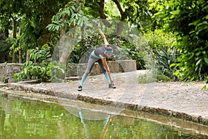 Lady Exercising Toe Touch Stretching Exercise In Park