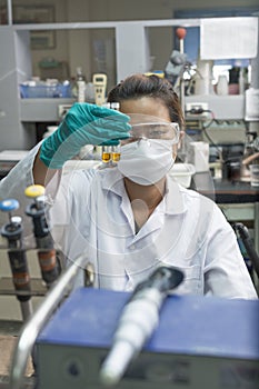 Lady experimenting chemicals in test glasses