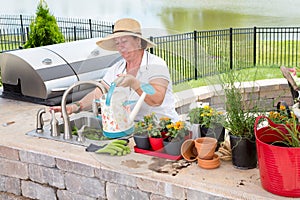 Lady filling a watering can on an outdoor patio