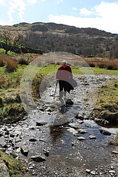 Lady on footpath crossing small stream