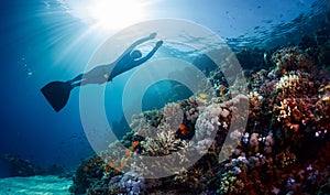 Lady freediver gliding underwater