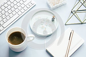 Lady freelancer's home pastel blue workplace, cup of coffee and computer keyboard on tabletop