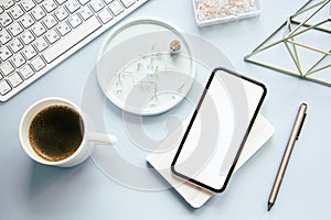 Lady freelancer's home pastel blue workplace, cup of coffee and smartphone mock-up on tabletop