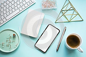 Lady freelancer's home pastel blue workplace, cup of coffee and smartphone mock-up on tabletop