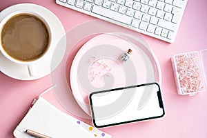 Lady freelancer's home pastel pink workplace, cup of coffee and smartphone mock-up