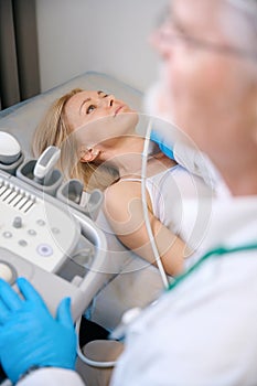 Lady getting her neck examined by doctor at modern clinic