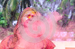 A lady getting showered with holi colours during holi festival in india