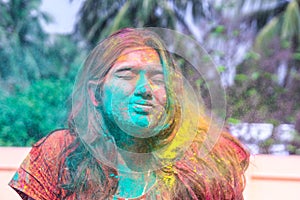 A lady getting showered with holi colours during holi festival in india