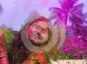 A lady getting showered with holi colours during holi festival in india