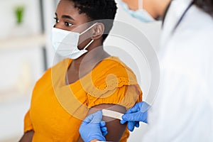 Lady Getting Vaccinated While Doctor Applying Plaster After Injection Indoors photo