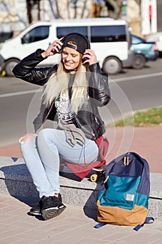 Lady girl happy smiles, sits skateboard