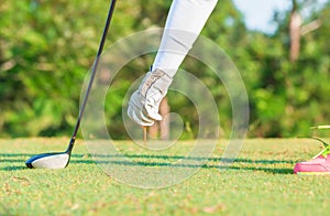 Lady golfer hand holding golf ball and golf tee.tif