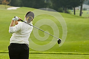 Lady golfer swinging driver