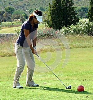 Lady golfer teeing off.