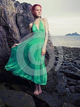 Lady in green dress on seashore