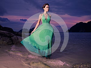 Lady in green dress on seashore