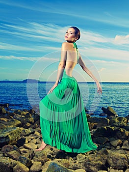 Lady in green dress on seashore