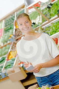 Lady in grocers with list photo
