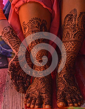 A lady hand & feet with indian heena mehandi in indian weddings