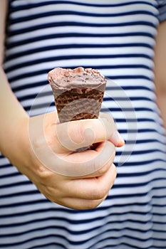 lady hand holding melted chocolate ice cream and missing bite