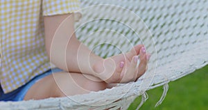 lady hand sitting on relaxed woman leg sitting and meditating in butterfly fly yoga asana in hammock extreme close view