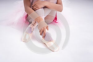 The lady hand is touching satin ballet shoe with right hand