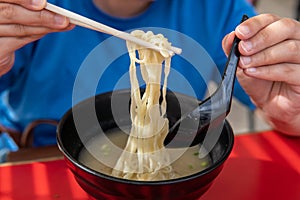 Lady hand using chopsticks eating noodle