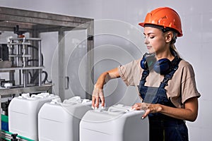 lady in hardhat closes the lid of canister container with pesticides, preparing