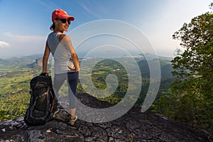 Lady hiker stands on the cliff