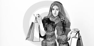 Lady hold shopping bags. Discount and sale. Fashionista buy clothes on black friday. Girl makeup furry coat shopping