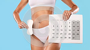 Lady holding calendar and pad isolated over blue studio background