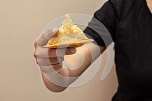 a lady holding Indian snack Samosa. Selective focus.