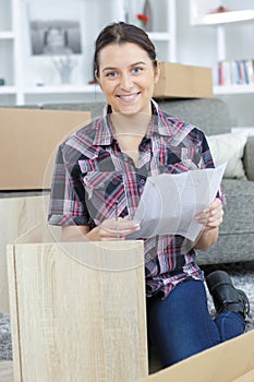 Lady holding instructions for assembling furniture
