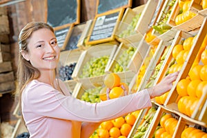 Lady holding oranges in greengrocers photo