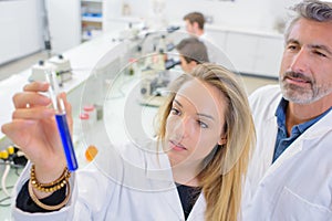 Lady holding test tube blue liquid