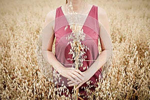 Lady holds in her hands ripe ears of oats. Concept of maturity photo