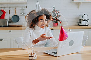 Lady with holiday cone conducts online birthday party