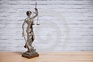 Lady Justice or Justitia the goddess of justice statue on desk - legal law legislation concept