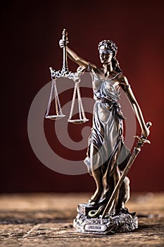 Lady Justicia holding sword and scale bronze figurine on wooden