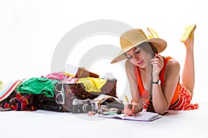 Lady lays near overfilled suitcase.