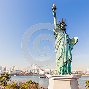 Lady liberty juxtaposed against Rainbow Bridge in Tokyo, Japan