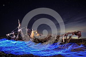Lady Light Painted on a Ghost Ship With Star Trails on Beach