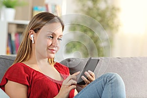 Lady listening to music with phone and wireless earbuds