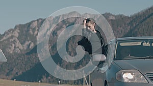 Lady with long dark hair sits on car window and enjoys life