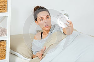 lady looking at alarmclock in disbelief