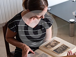 Lady Looking at old Black and White Vintage Photos Scrolling through the Pages of a Photo Album