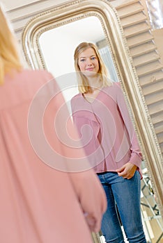 Lady looking at reflection in mirror photo