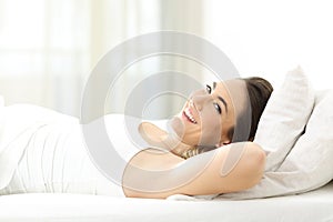 Lady lying on a comfortable mattress looks at you