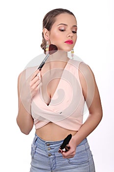 Lady with makeup brush looking down. Close up. White background