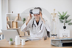 Lady medic looking into virtual glasses in modern office